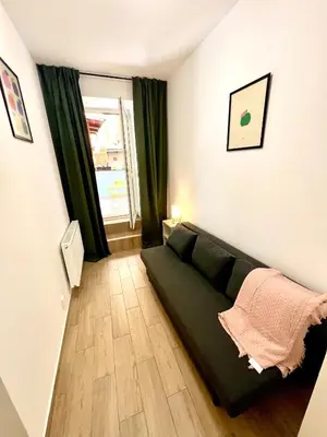 a living room with a green couch and a window at Holeckova125 in Prague