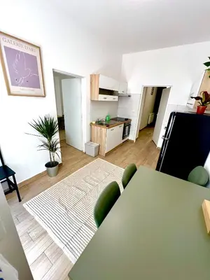 a living room with a green table and a kitchen at Holeckova125 in Prague