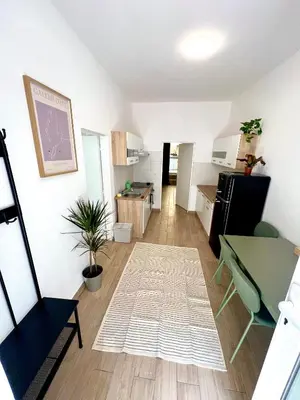 a living room with a table and a kitchen at Holeckova125 in Prague