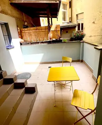 a yellow table and two chairs on a balcony at Holeckova125 in Prague