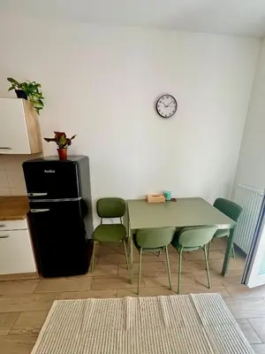 a kitchen with a table and chairs and a clock on the wall at Holeckova125 in Prague