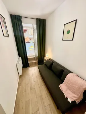 a living room with a black couch and a window at Holeckova125 in Prague