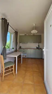 a kitchen with a table and a dining room at Apartmán ANNA