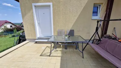 a glass table on the patio of a house at Apartmán ANNA