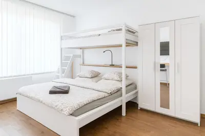 a bedroom with a bunk bed and a dining room with a table at Quiet Stay and Parking in Prague