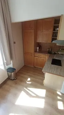 a kitchen with wooden cabinets and a counter top at Bright and cozy - 3 min to Old town square in Prague