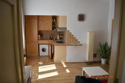 a kitchen with wooden cabinets and a counter top at Bright and cozy - 3 min to Old town square in Prague