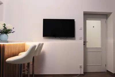 a living room with a tv on a white wall at Stylish Stay at the Heart of Prague! in Prague