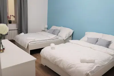 two beds in a room with a blue wall at Stylish Stay at the Heart of Prague! in Prague