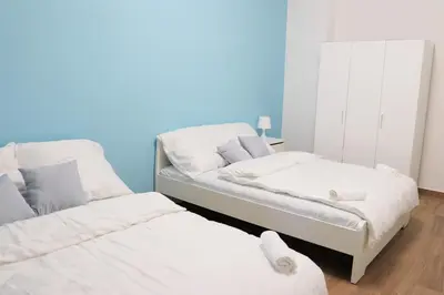two beds in a room with blue walls at Stylish Stay at the Heart of Prague! in Prague