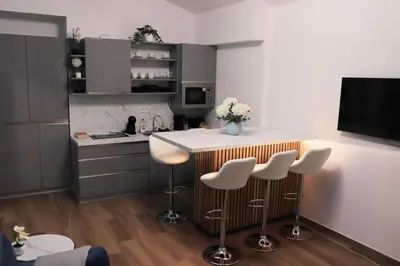 a kitchen with a counter and a table with stools at Stylish Stay at the Heart of Prague! in Prague