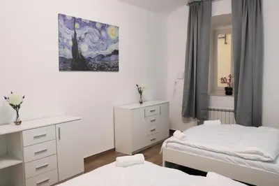 a bedroom with two beds and a painting on the wall at Stylish Stay at the Heart of Prague! in Prague