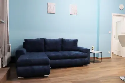 a blue couch in a living room with a table at Stylish Stay at the Heart of Prague! in Prague