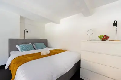 a white bedroom with a bed with towels on it at Loft cozy studios in Prague Center in Prague