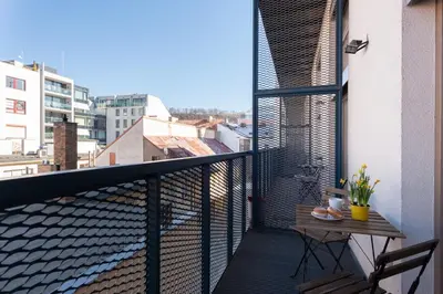 a balcony with a table and a view of a city at Loft cozy studios in Prague Center in Prague