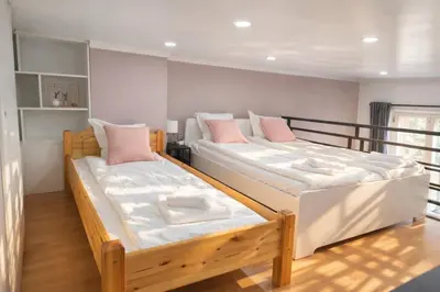 two beds in a room with white and pink pillows at Prague Center Apt - 2 min to Wenceslas Sq, Praha 1 in Prague