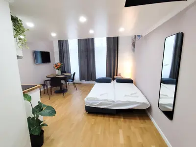 a living room with a bed and a table at Prague Center Apt - 2 min to Wenceslas Sq, Praha 1 in Prague