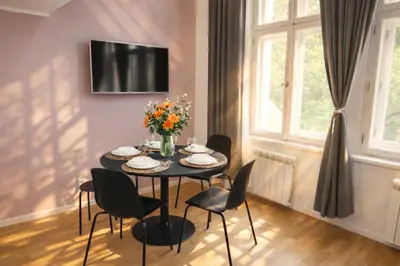 a living room with a blue couch and some flowers at Prague Center Apt - 2 min to Wenceslas Sq, Praha 1 in Prague