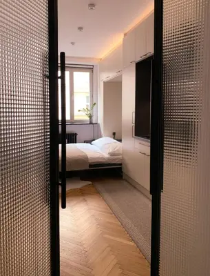 a bedroom with a bed and a tv and a sliding door at Cosy Apartment near City Center in Prague