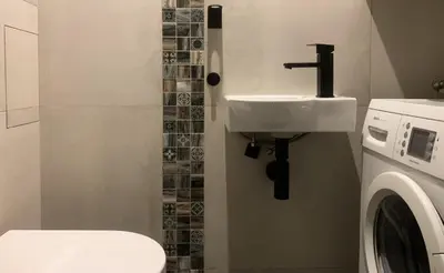 a bathroom with a sink and a washing machine at Cosy Apartment near City Center in Prague