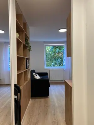a living room with a black couch and a window at Cozy studio in centre of prague 10 Vrsovice in Prague