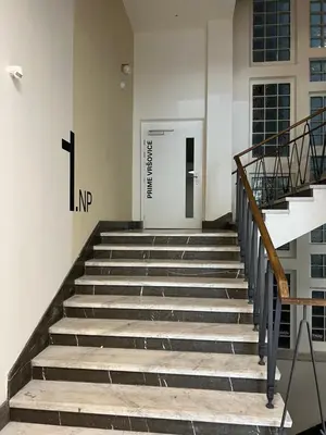 a staircase in a building with a letter n on the wall at Cozy studio in centre of prague 10 Vrsovice in Prague