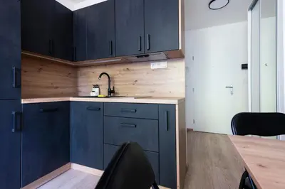 a kitchen with blue cabinets and a sink and a table at Cozy studio in centre of prague 10 Vrsovice in Prague