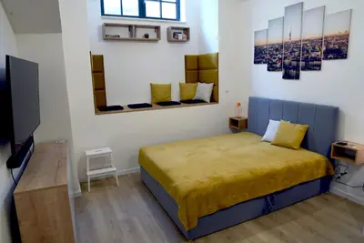 a bedroom with a bed and a flat screen tv at The Nook I Soukromý apartmán v srdci Prahy in Prague