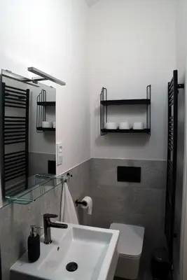 a bathroom with a sink and a toilet and a mirror at The Nook I Soukromý apartmán v srdci Prahy in Prague