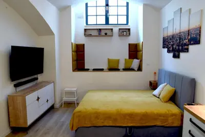 a bedroom with a bed and a flat screen tv at The Nook I Soukromý apartmán v srdci Prahy in Prague
