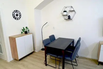 a dining room with a table and chairs and a clock at The Nook I Soukromý apartmán v srdci Prahy in Prague