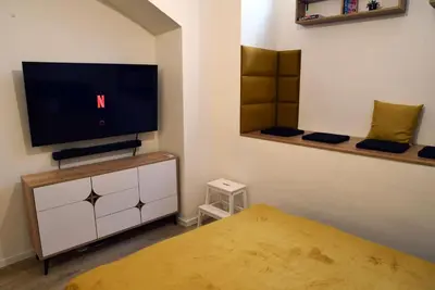 a bedroom with a flat screen tv and a bed at The Nook I Soukromý apartmán v srdci Prahy in Prague