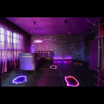 a room with a tub and purple lights on the floor at Apartman made by David Černý in Prague