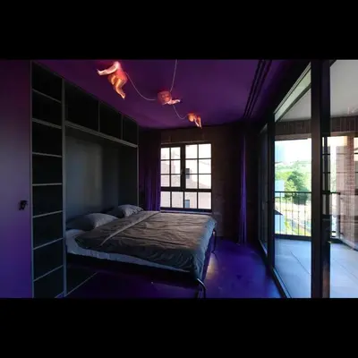 a bedroom with a bed with purple ceilings and windows at Apartman made by David Černý in Prague
