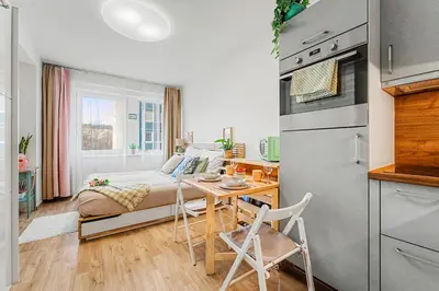a small apartment with a bed and a table and a kitchen at Stylish Studio in Smichov, Private parking, Free Gym in Prague