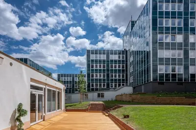 a garden with a tree in the middle of a building at Stylish Studio in Smichov, Private parking, Free Gym in Prague