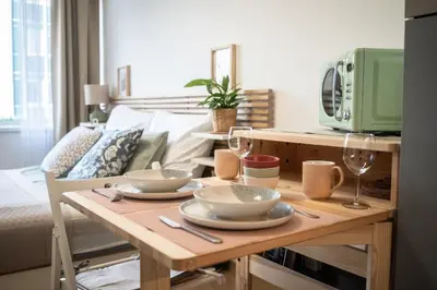 a table with plates and wine glasses on it in a living room at Stylish Studio in Smichov, Private parking, Free Gym in Prague