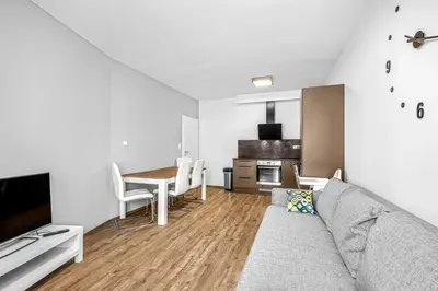 a living room with a couch and a table and a kitchen at New cozy apartment, Free Parking! in Prague