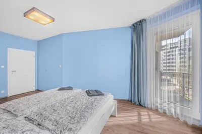a bedroom with a bed and a large window at New cozy apartment, Free Parking! in Prague