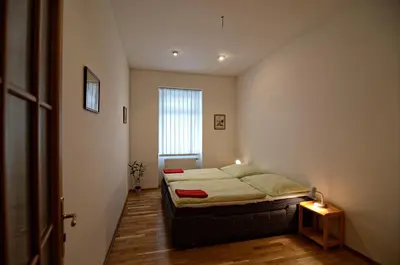 a small bedroom with a bed and a window at Apartments Karlin in Prague