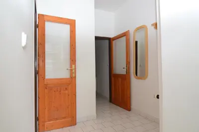 a hallway with two wooden doors and a mirror at Apartments Karlin in Prague
