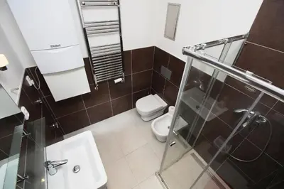 a bathroom with a toilet and a glass shower at Apartments Karlin in Prague