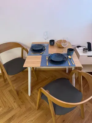 a wooden table with plates and wine glasses on it at LublaDeluxe in Prague