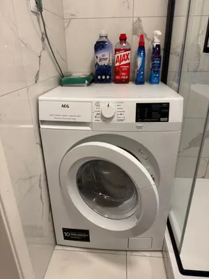 a washing machine with bottles on top of it at LublaDeluxe in Prague