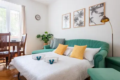 a living room with a green couch and a bed at Cozy Jungle Apartment in Prague