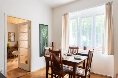 a dining room with a table and chairs and a window at Cozy Jungle Apartment in Prague