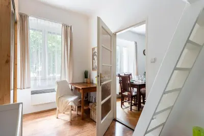 a living room with a dining room table and a door at Cozy Jungle Apartment in Prague