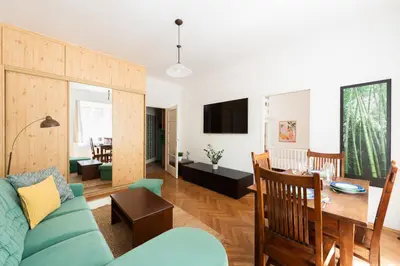 a living room with a blue couch and a dining room at Cozy Jungle Apartment in Prague