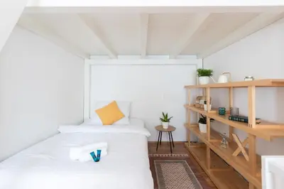 a bedroom with two beds and a book shelf at Cozy Jungle Apartment in Prague