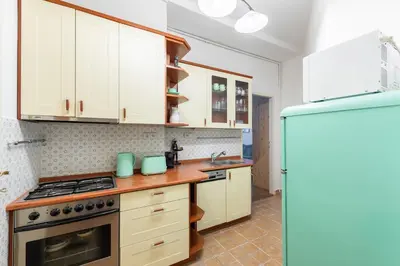 a kitchen with white cabinets and a stove top oven at Cozy Jungle Apartment in Prague